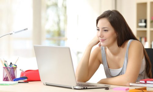 Student studying and learning online with a laptop in a desk at home